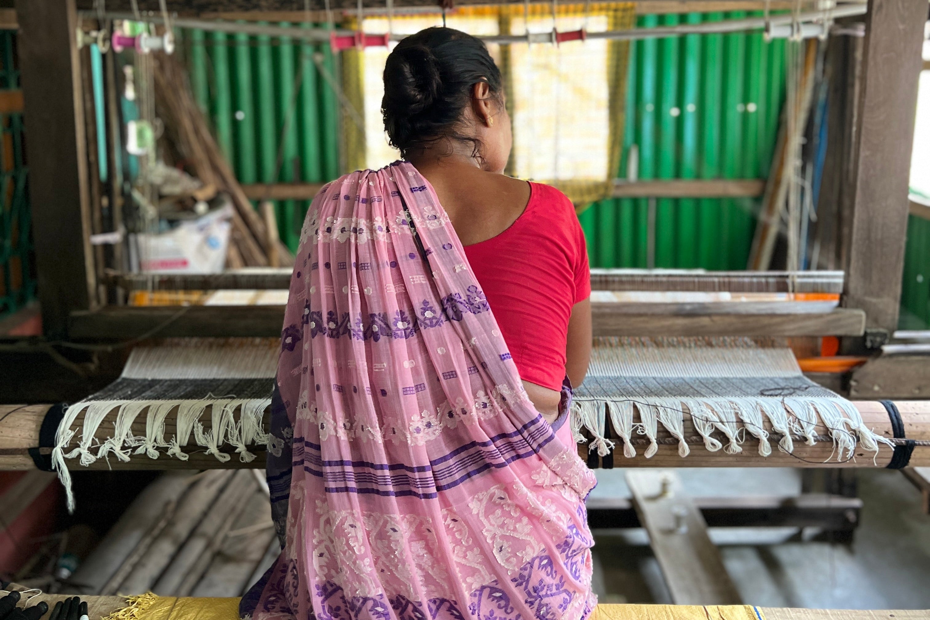 Woman working on a loom in a weaving shed